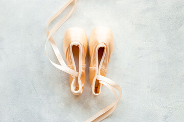 Pair of beige ballet pointe shoes with ribbon, top view