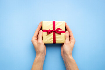 Golden gift box in female hands. Present for Christmas