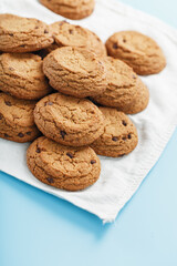 Oatmeal cookies on a blue background and a white napkin top view