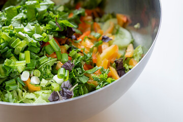 Fresh healthy vegan salad with greens and pepper in the big bowl close up	
