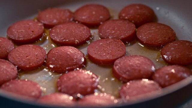 Turkish sausage is cooked in a pan in slow motion. One of the traditional Turkish breakfast dishes is eggs with sausage. Salami omelet. Macro, 4K, Phantom Camera, Super Close Up. Super slow motion.