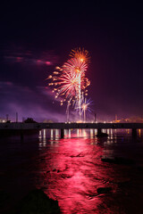 Independence Day fireworks over water with bridge , 