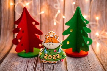 Tiger is the symbol of the year 2022. A tiger in the form of a gingerbread with number 2022. Symbol of the year. Beautiful tiger on a wooden background. Christmas composition with a homemade tiger. 