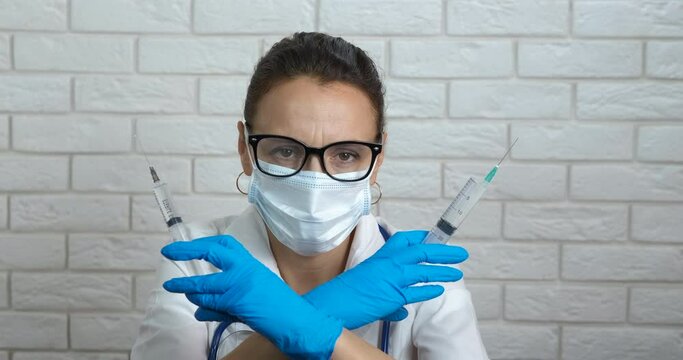 Doctor and medical concept with injection. A medical worker posing with two syringe with drug in the room.