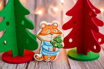 Tiger 2022. Gingerbread tigers on wooden background with christmas tree. 2022. Christmas card with tiger. Christmas tree with santa claus.