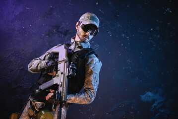 Futuristic soldier with a rifle on the black smoky background.