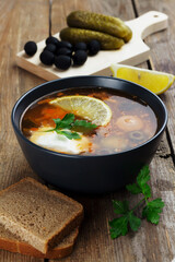 Traditional russian meat soup Solyanka in a bowl and ingredients