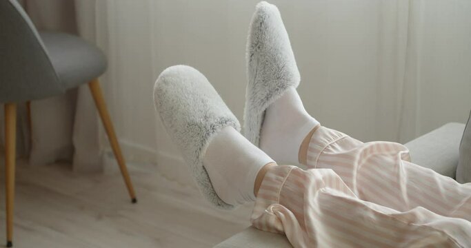 Young woman in soft slippers resting at home