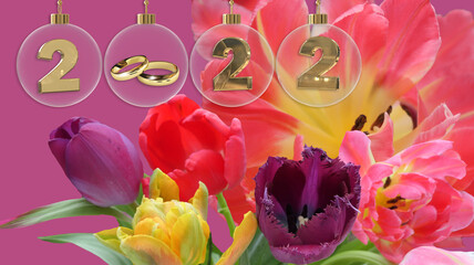 golden wedding rings in transparent glass bauble 2022 digits and brightly coloured spring bouquet in the background
