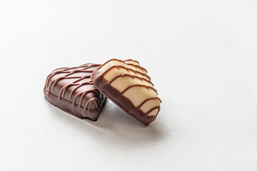 dark and white chocolate candies in the shape of hearts on a white surface