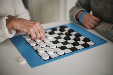 Family time - grandmother playing checkers with her grandson