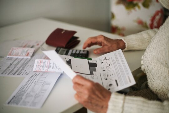 Senior sitting at the table counting bills
