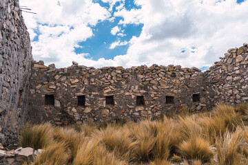 archaeological remains of a temple made of stones and mud on a sunny day with clouds and blue sky...