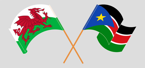 Crossed and waving flags of Wales and South Sudan