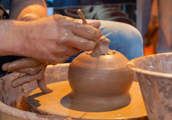 Potter making ceramic mug on the pottery wheel