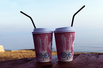 Two cardboard glasses. Behind you can see the sea surface.