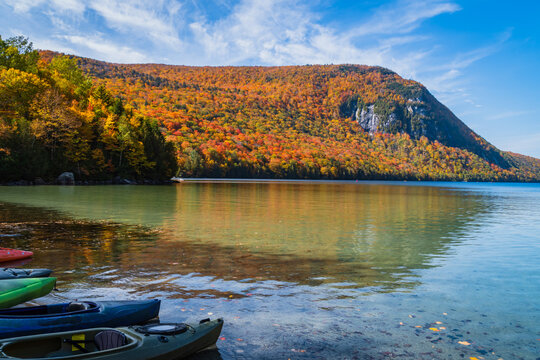 kayaks lined up along the shore of Lake Willoughby on a Vermont Autumn afternoon
