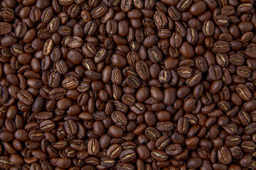 Fototapeta premium A background of randomly scattered roasted coffee beans. Presentation layout.