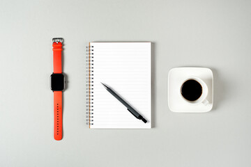 Notepad, watch, pen and a cup of coffee isolated on light gray background. Notepad with copy space....