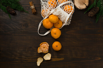 Fresh mandarin oranges fruit or tangerines on a wooden table. Christmas composition with tangerines, fir branches, cinnamon sticks. Flat lay, top view - 477521845