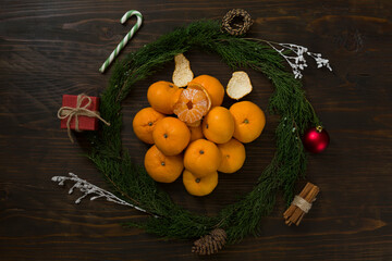 Fresh mandarin oranges fruit or tangerines on a wooden table. Christmas composition with tangerines, fir branches, cinnamon sticks. Flat lay, top view - 477521858