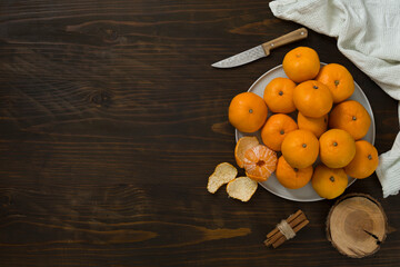 Fresh mandarin oranges fruit or tangerines on a wooden table. Christmas composition with tangerines, fir branches, cinnamon sticks. Flat lay, top view - 477521877