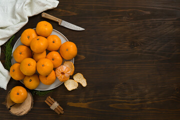 Fresh mandarin oranges fruit or tangerines on a wooden table. Christmas composition with tangerines, fir branches, cinnamon sticks. Flat lay, top view - 477521882