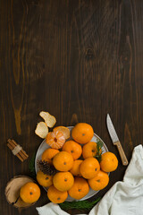 Fresh mandarin oranges fruit or tangerines on a wooden table. Christmas composition with tangerines, fir branches, cinnamon sticks. Flat lay, top view - 477521887