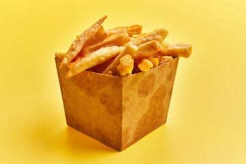  Delivery box of french fried potatoes over yellow background