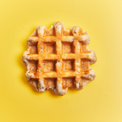  Single delicious waffle over yellow background