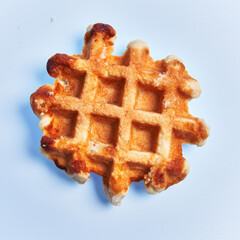  Single delicious waffle over blue background