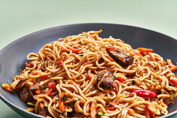  Plate of delicious noodles over green background