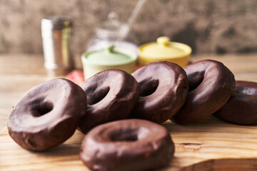  Bunch of chocolate doughnuts on a wooden surface