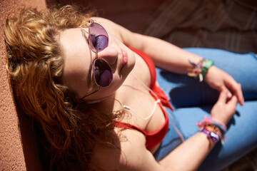Naklejka premium Caucasian girl sunbathing with sunglasses overhead view