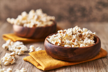  Bowls of salty popcorns on a wooden surface