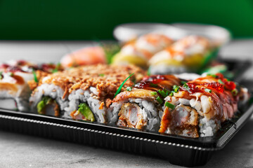  Delivery tray of uramaki sushi on a concrete surface