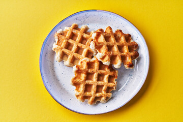  Plate of delicious waffles over yellow background