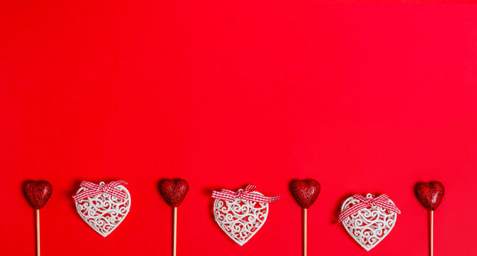 White and shiny hearts on a red background for Valentine's Day