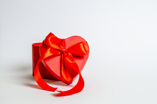Cover from a gift box with a ribbon in the form of a heart on a white background