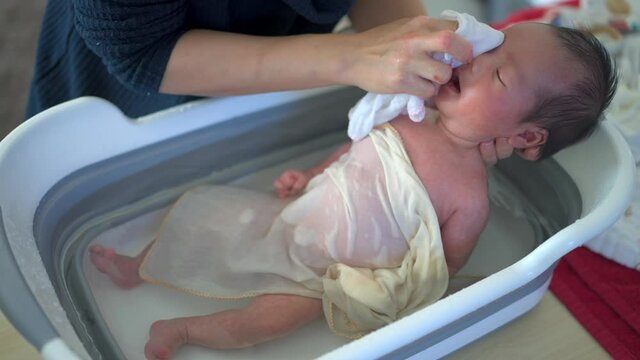bathing newborn asian baby boy