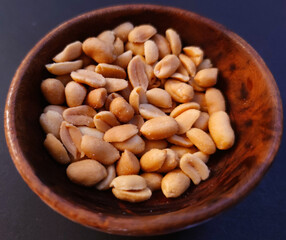 Peeled peanuts on a background in a wooden bowl