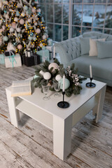 table with New Year's decor by the sofa. decorated christmas tree new year design interior