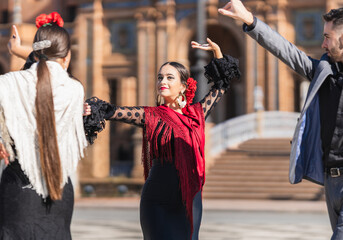 Selective focus on a woman dancing flamenco with two dancers outdoors - obrazy, fototapety, plakaty