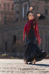 Woman in black and red flamenco dress dancing outdoors