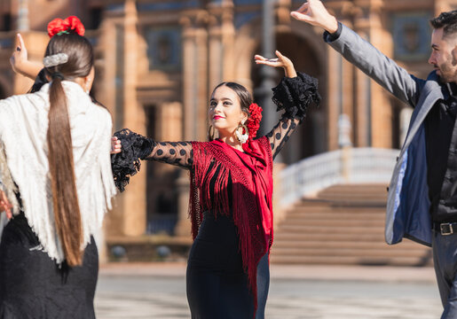Selective focus on a woman dancing flamenco with two dancers outdoors
