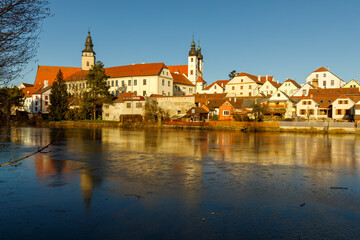 Fototapeta na wymiar Castle Park and Telc Castle. View of the city of Telc in the winter sunset. The picturesque castle and the historic center with the decorative facades of the houses belong to the UNESCO World Heritage