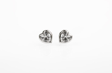 Hearts-shaped silver stud earrings on white background