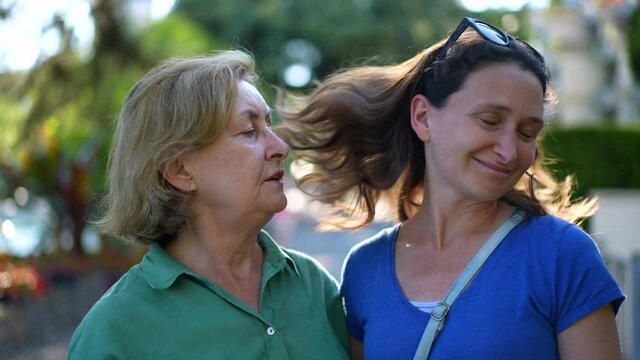 Woman untying hair. adult daughter posing for with photo with mother shakes hair