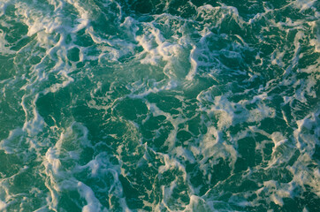 Bubble and sea water foam texture in ocean green water.