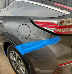 Rear Bumper broken. After the accident put blue adhesive tape on bumper and vehicle body. at the parking lot.